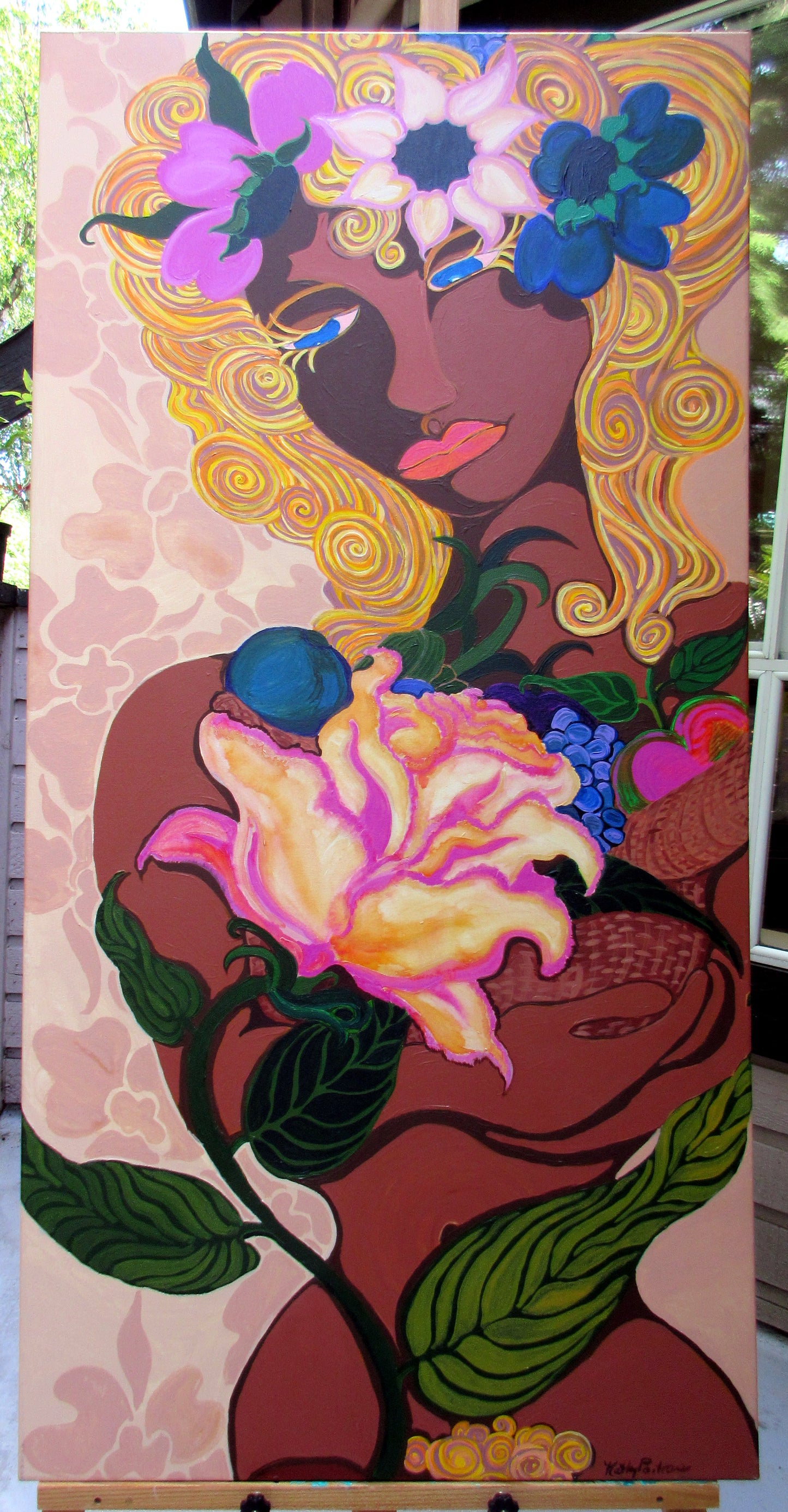 Acrylic painting on gallery-wrapped canvas showing a stylized woman with golden hair, blue eyes, and rich brown skin, partially hidden behind a large yellow and pink rose. She holds a basket of fruit in her oversized, expressive hands, surrounded by lush green leaves and soft pink abstract patterns. Titled Woman by Canadian artist Kathy Poitras.