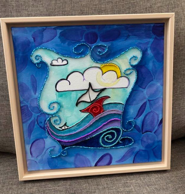 This vibrant coastal artwork features a whimsical sailboat gliding across swirling blue and purple waves beneath a bright yellow sun and soft, billowing clouds. Decorative patterns frame the scene, adding movement and charm, while bead‑embroidered accents bring subtle texture and sparkle. Set in a light wooden frame, the piece blends playful illustration with fine‑art detail, creating a joyful, uplifting coastal moment