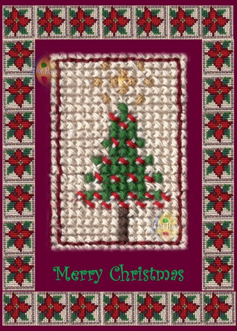 Photographic print of a festive Christmas card featuring a cross-stitch-style Christmas tree with green branches, red decorations, and a brown trunk, topped with yellow stitches resembling a star. The tree is set against a light woven fabric background and framed by a beige border with red and green poinsettia flowers arranged in a grid pattern. The outer background is deep burgundy, with “Merry Christmas” stitched in green at the bottom center.